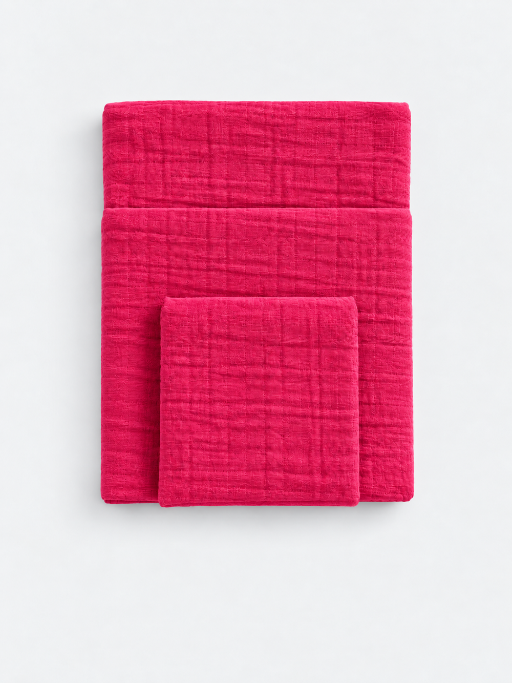 Raspberry Soda cotton muslin towels folded on a light background