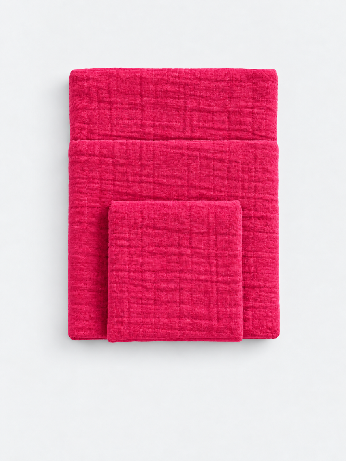 Raspberry Soda cotton muslin towels folded on a light background