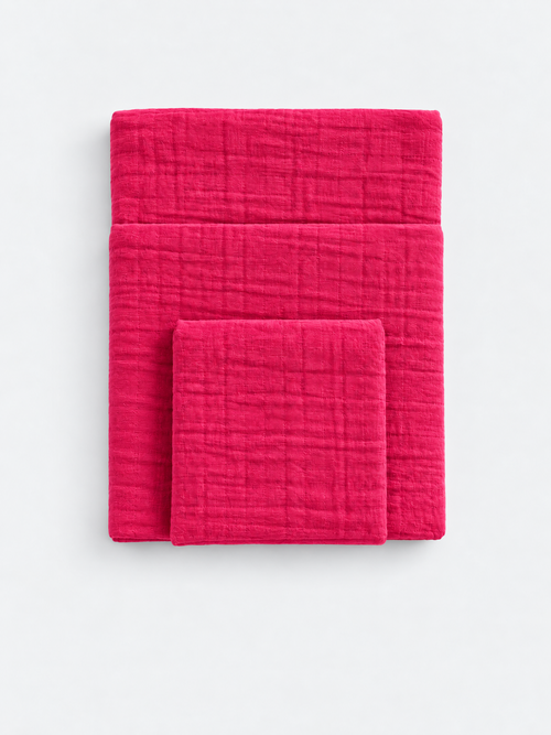 Raspberry Soda cotton muslin towels folded on a light background