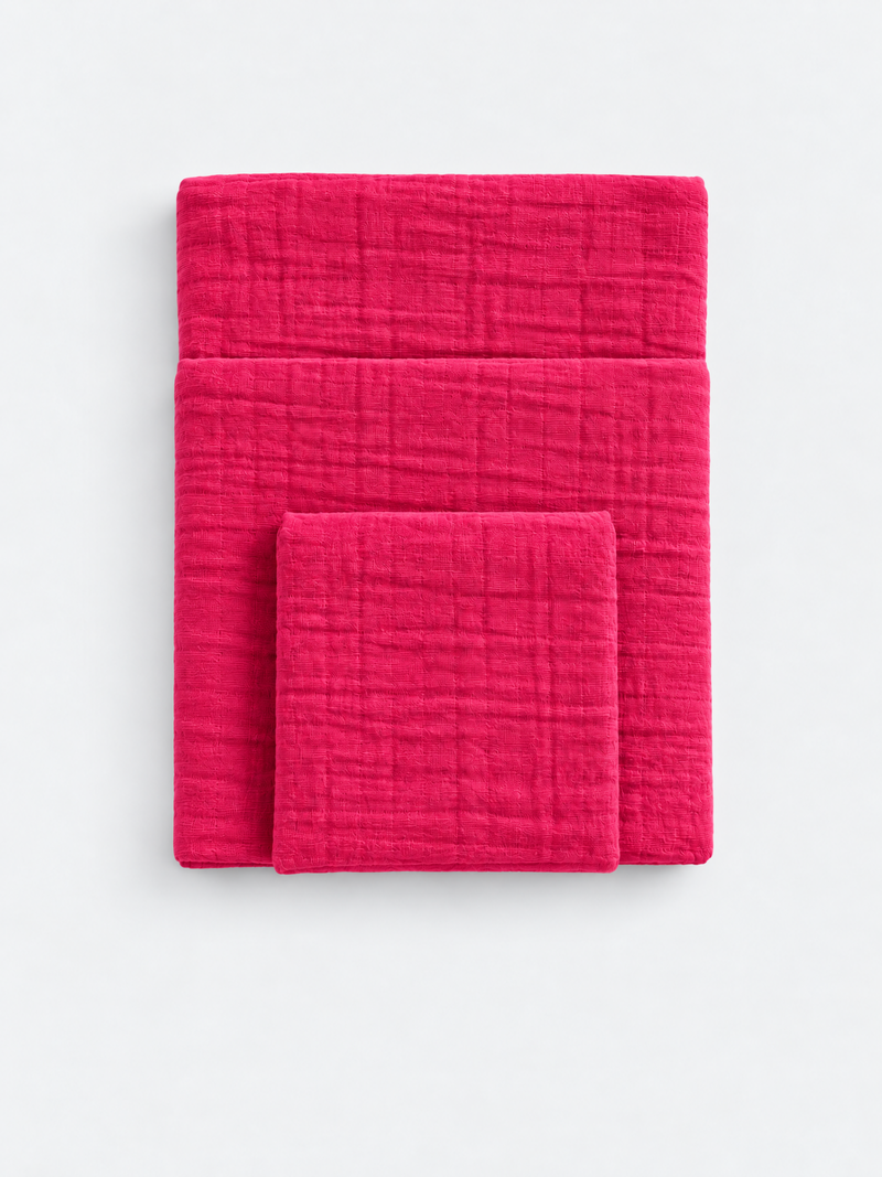 Raspberry Soda cotton muslin towels folded on a light background