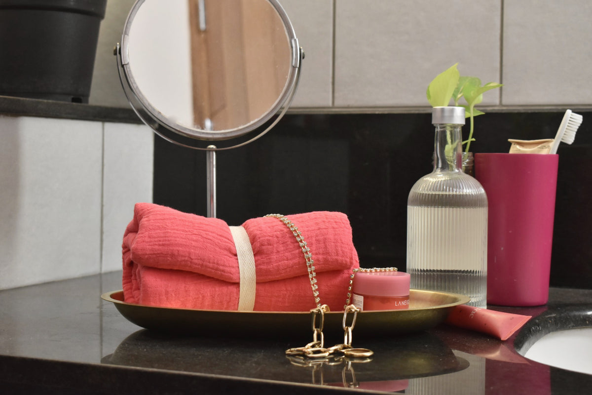 White Flowerr coral muslin towel styled on a vanity tray with jewellery