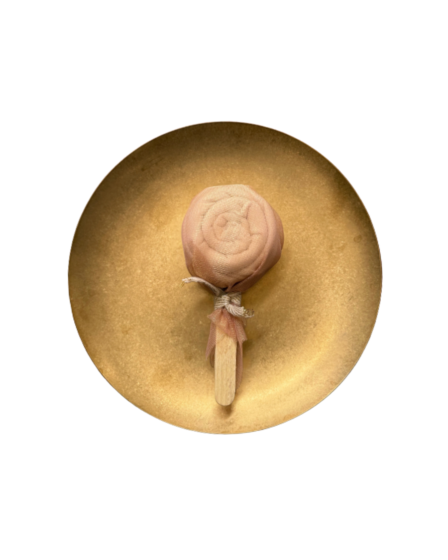 Lollipop-style muslin fold on a gold plate