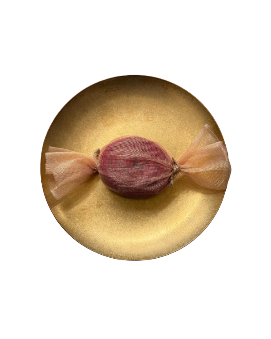 Wrapped red muslin rose on a gold plate