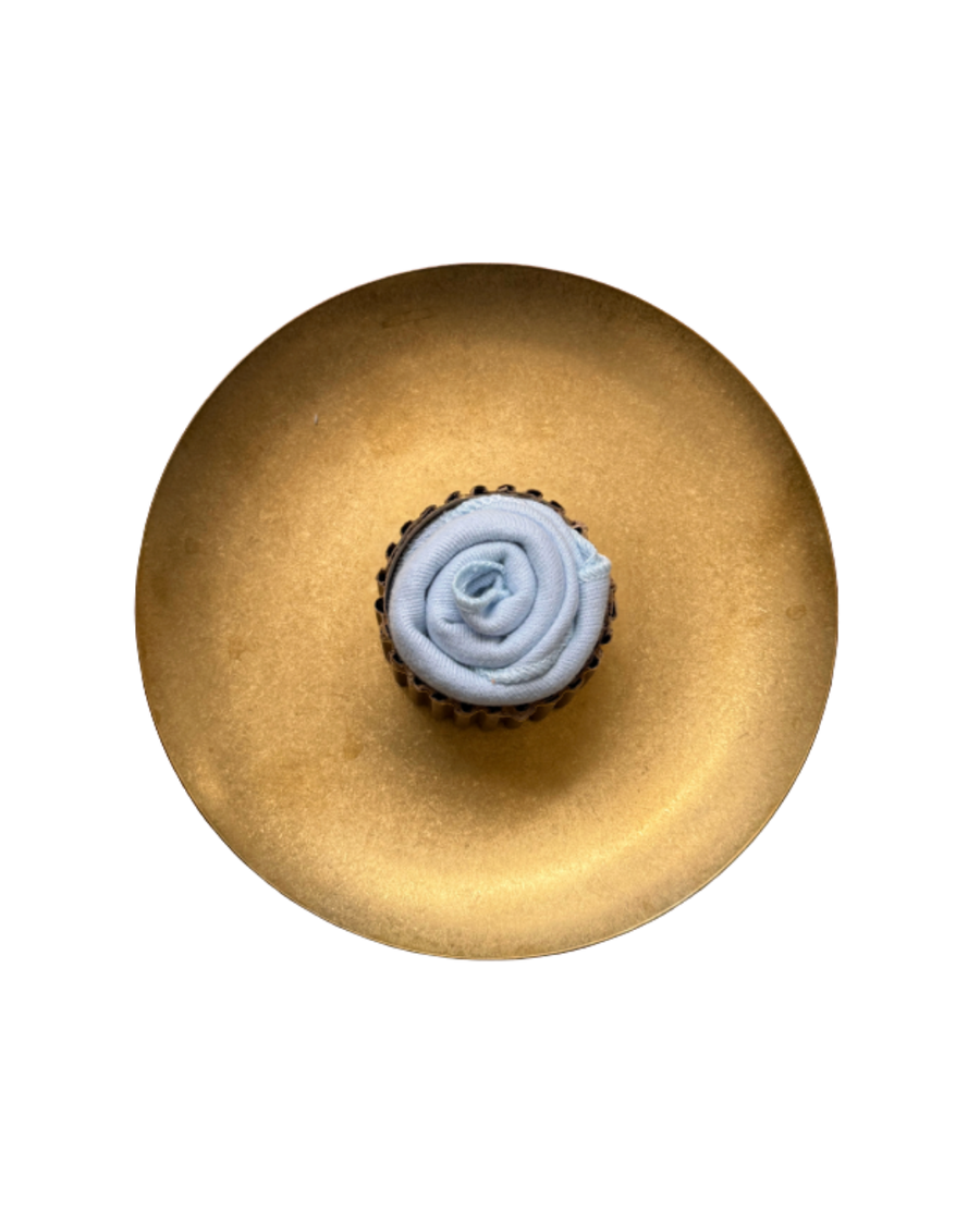 Blue cupcake-style muslin fold on a gold plate