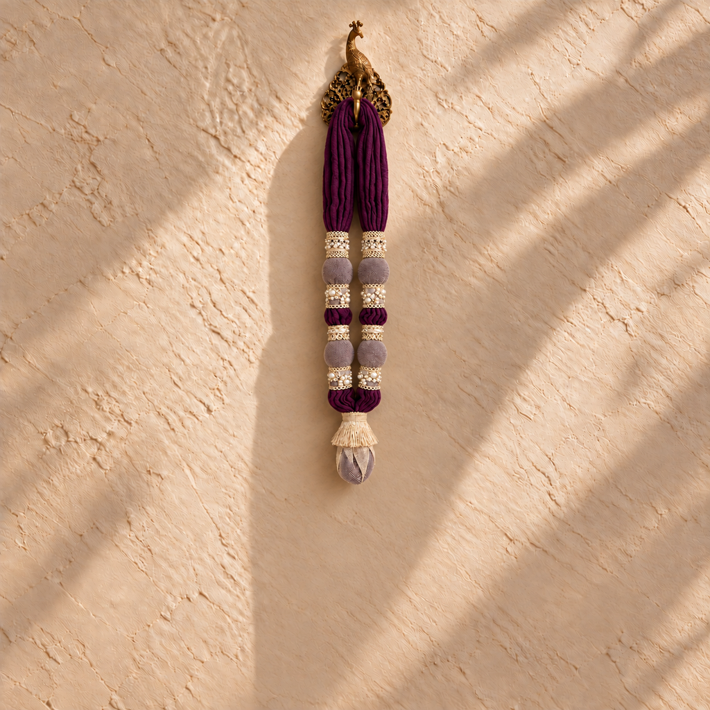 The Mini Maala by White Flowerr, purple cotton muslin towel garland with gold and pearl trims on a gold peacock hook