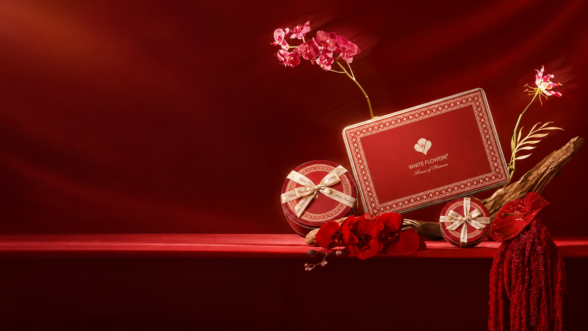 White Flowerr red gifting cases arranged with flowers against a red backdrop