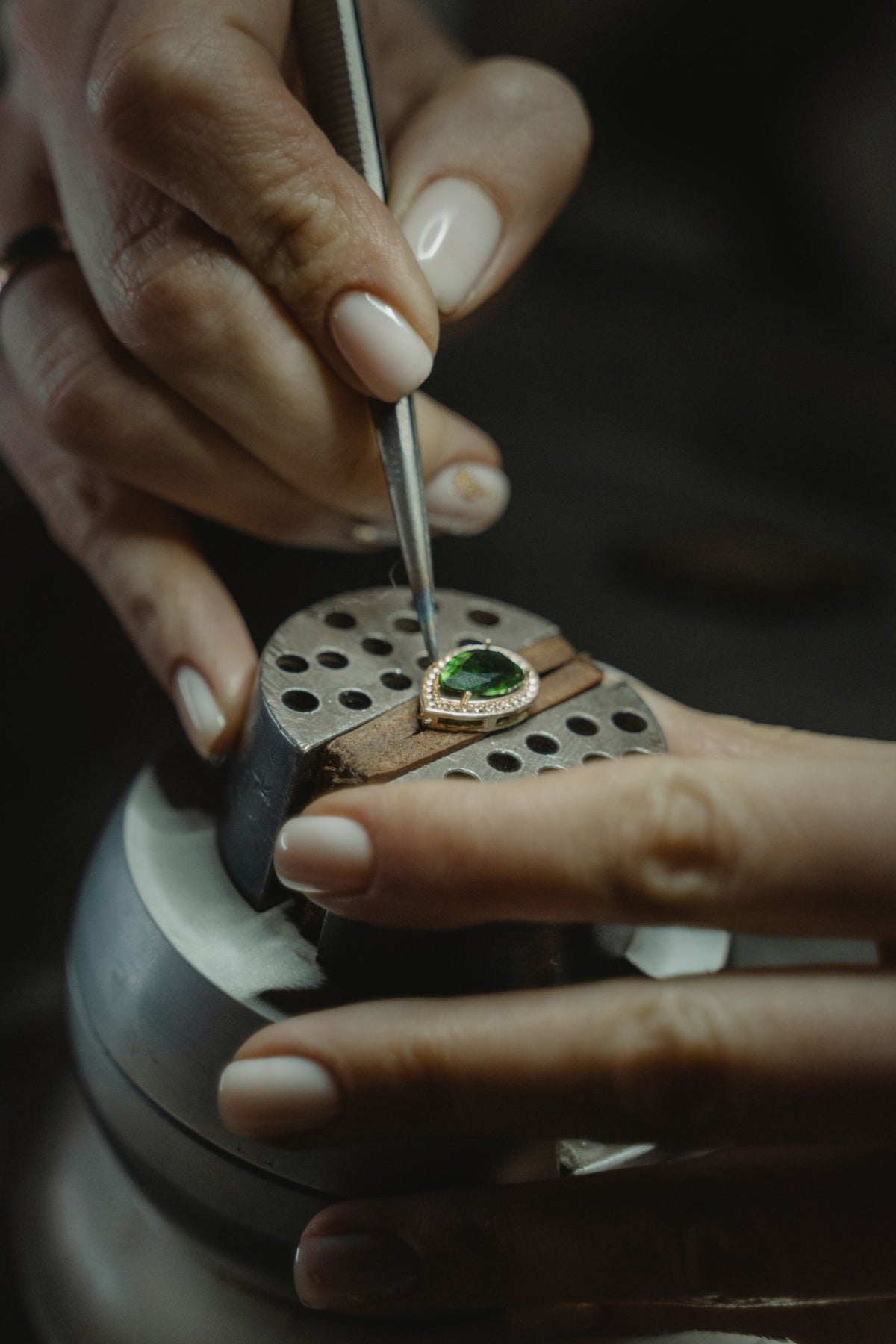Jeweller setting a green gemstone by hand